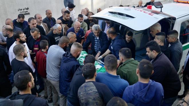 Palestinian mourners gather round the body of Basel Abu al-Wafa, 14, after he was killed during an Israeli military raid in Jenin, in the occupied West Bank (29 November 2023)