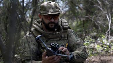 A soldier looking at drone in the field