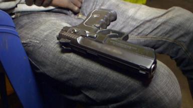 A handgun sitting on someone's knee
