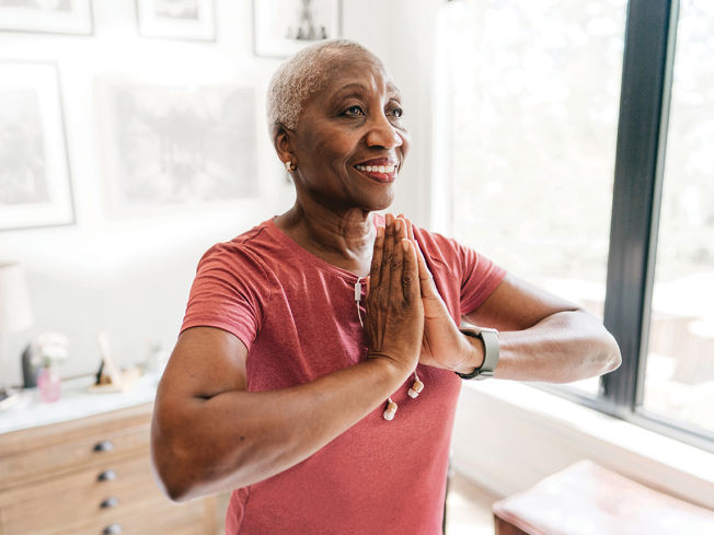 Older woman practicing yoga in her apartment