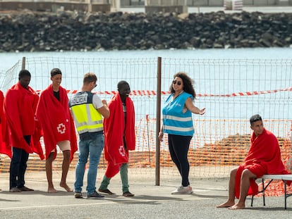 Un agente de la Policía Nacional y otra de Frontex, la agencia europea de fronteras, reciben a los ocupantes de una embarcación en el puerto de Arrecife, el pasado 18 de octubre.
