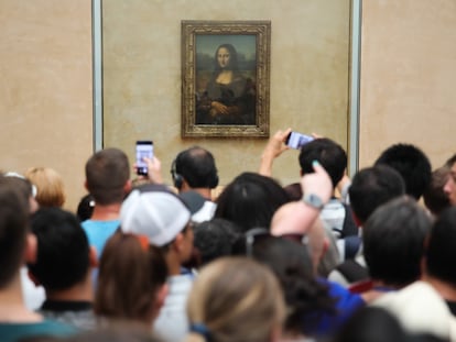 Un grupo de visitantes del Louvre observa y fotografía 'La Gioconda'.