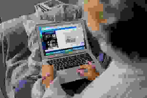 Person sitting on couch using Canva on their laptop. Photo by Ron Lach