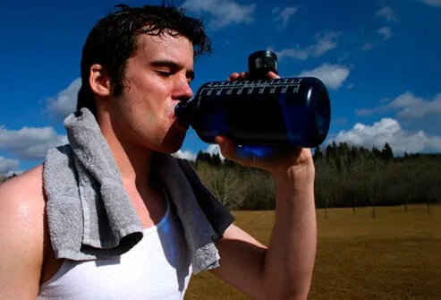 A man drinks water after running on a hot day.