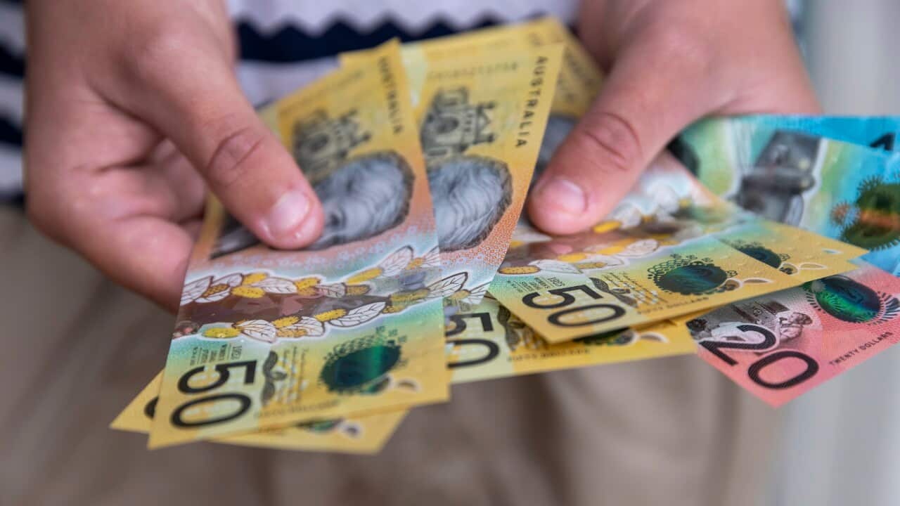 A person holding Australian banknotes.