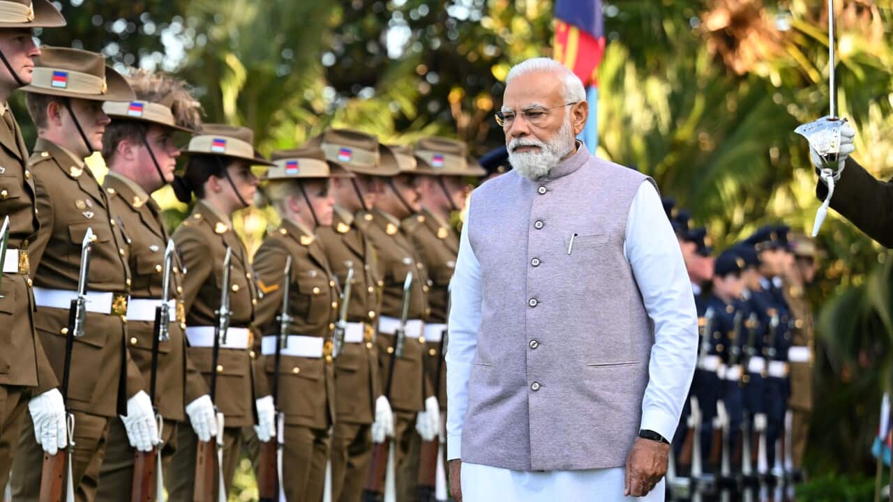Narendra Modi walks in front of Australian soldiers standing at attention