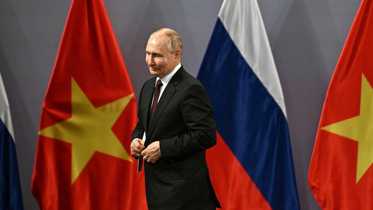 Vladimir Poutine devant des drapeaux russes et vietnamiens.