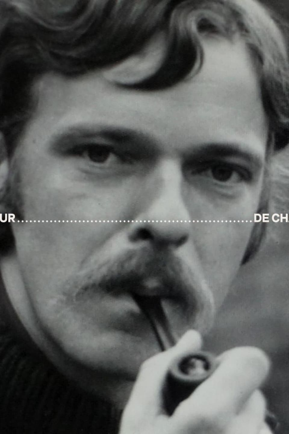 Sur la photo, Yves fume une pipe en regardant la caméra. Les mots « dépoussiéreur de folklore » sont ajoutés en photomontage par dessus l'image d'archives en noir et blanc.