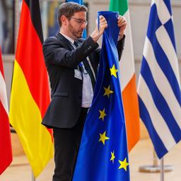 Ein Mitarbeiter bereitet vor einem Treffen in Brüssel (Belgien) die Aufstellung der Flaggen vor.