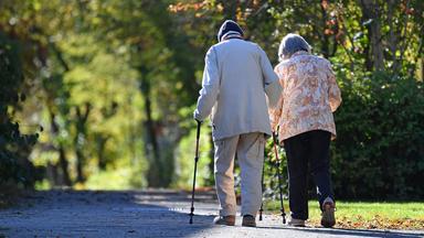Ein alter Mann und eine alte Frau gehen spazieren.