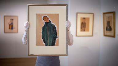 Eine Galerieassistentin posiert mit dem Gemälde "Junge im grünen Mantel" des österreichischen Malers Egon Schiele in der Ausstellung bei Bonhams in London.