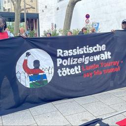 Mit einem großen Banner demonstrieren Menschen in Stuttgart gegen Polizeigewalt. Auslöser war der Tod des Gambiers Lamin Touray. 