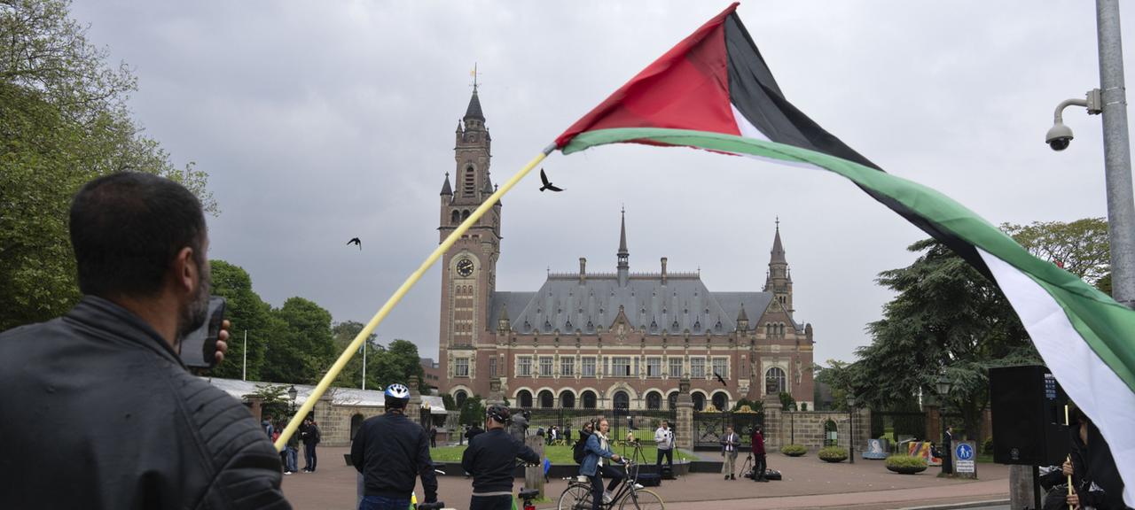Ein Demonstrant schwenkt die palästinensische Flagge vor dem Friedenspalast, in dem der Internationale Gerichtshof in Den Haag sitzt.
