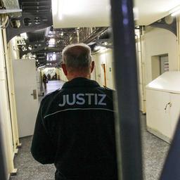 Symbolbild: Justizbeamter im Flur der Untersuchungshaftanstalt Moabit in Berlin mit geschlossenen Zellentüren. (Quelle: dpa/Kremming)