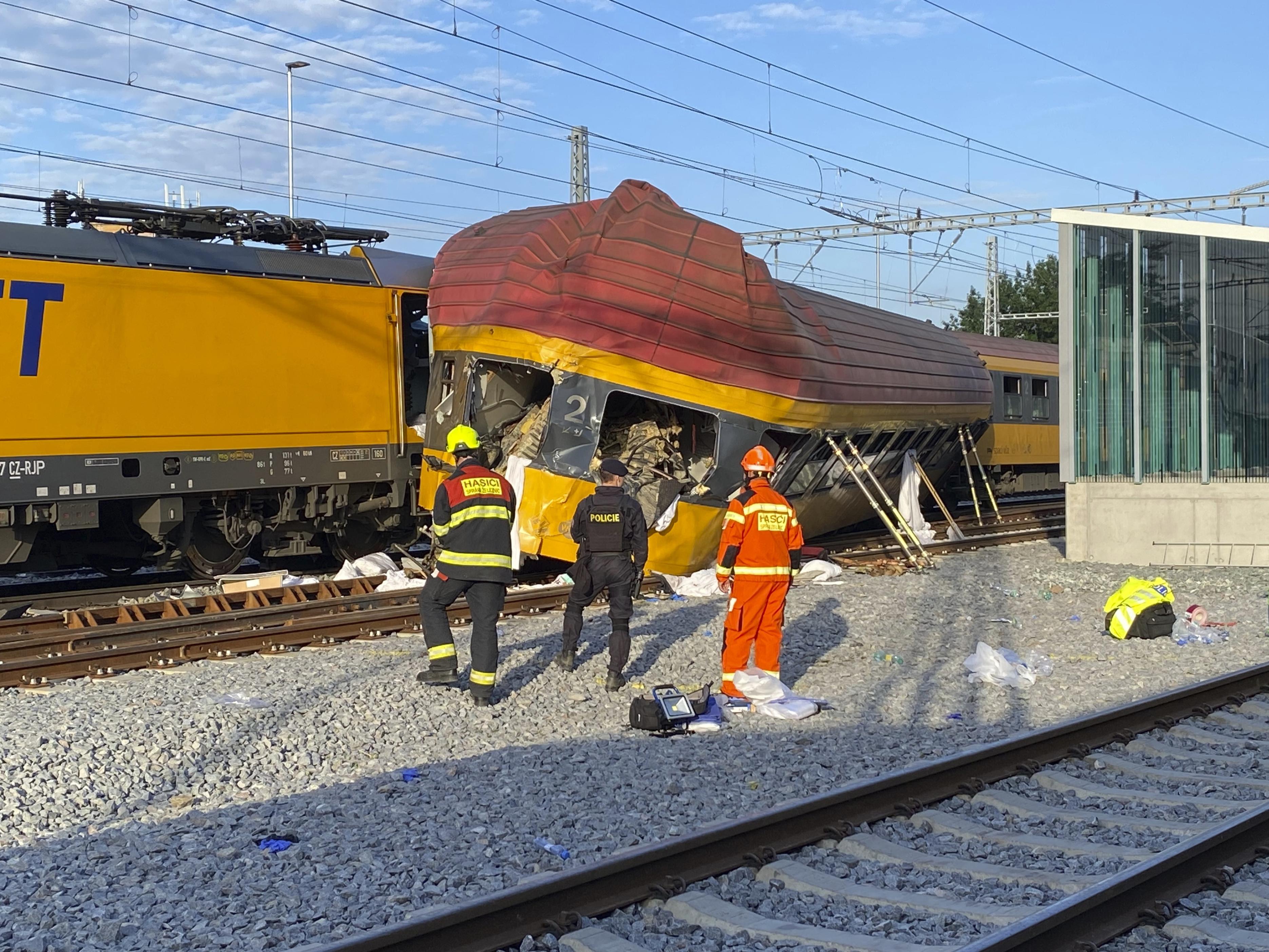 衝突事故を起こした列車のそばに立つ消防士ら＝6日、チェコ・パルドゥビツェ（AP＝共同）