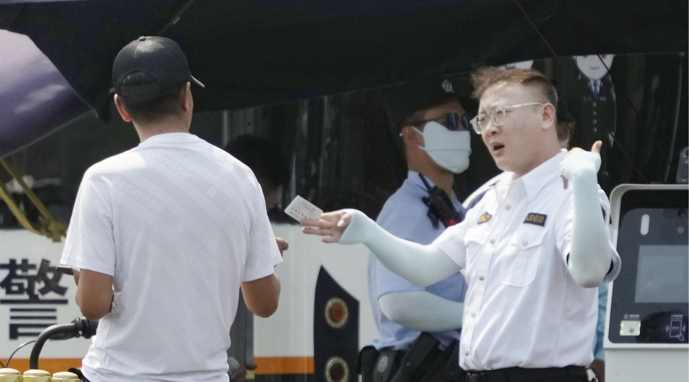 路上で通行人の身分証をチェックする警察官＝4日、北京（共同）