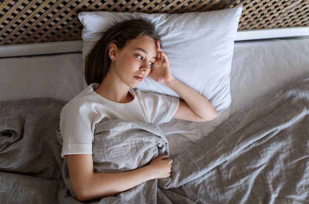 Top view anxious woman laying in bed