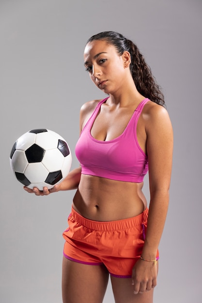 Молодая женщина в спортивной одежде держит мяч