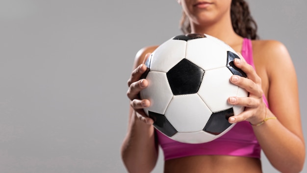 Крупным планом женщина, держащая футбольный мяч