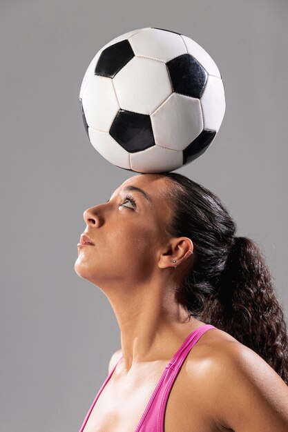 Макро взрослая женщина, держа мяч на голове