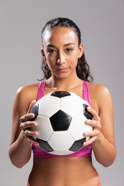Вид спереди женщина, держащая футбольный мяч