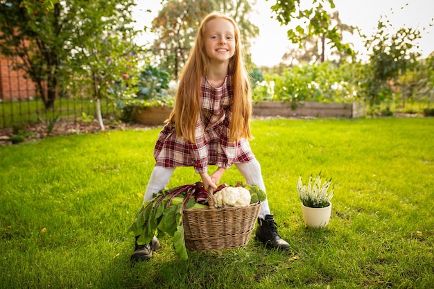 Бесплатное фото Счастливая маленькая девочка, собирающая яблоко, сезонные продукты в саду на открытом воздухе