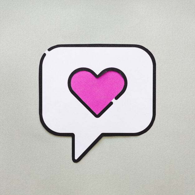 Heart in bubble speech icon on grey table