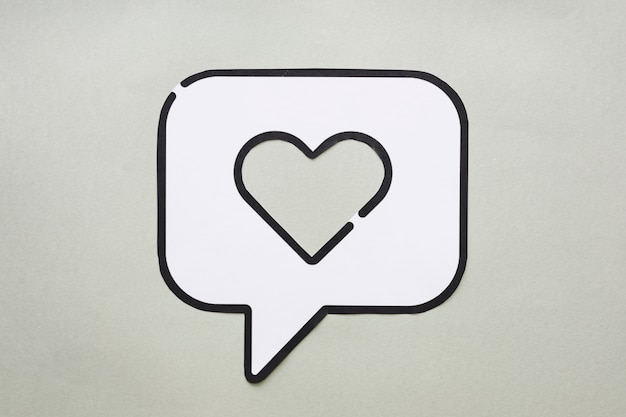 Heart in bubble speech icon on table