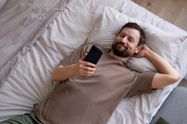 Man on bed with smartphone