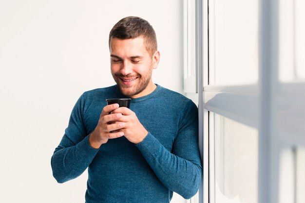 Medium view of man holding a cup of coffee