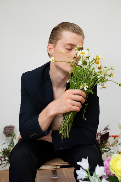 Free photo portrait of man posing with flowers