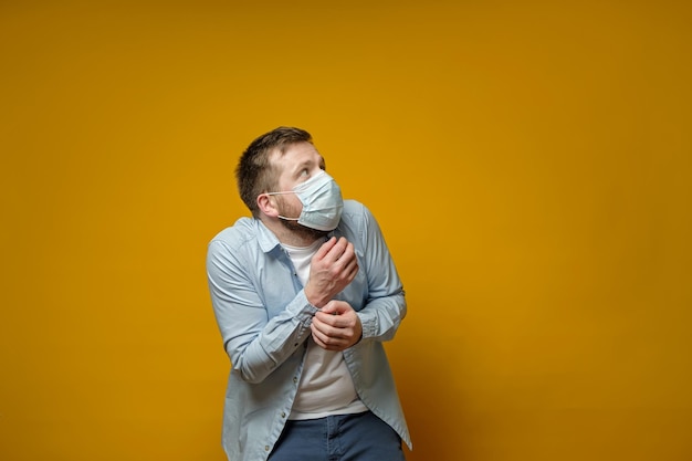Европеец в защитной медицинской маске очень напуган, он боится заразиться опасным вирусом