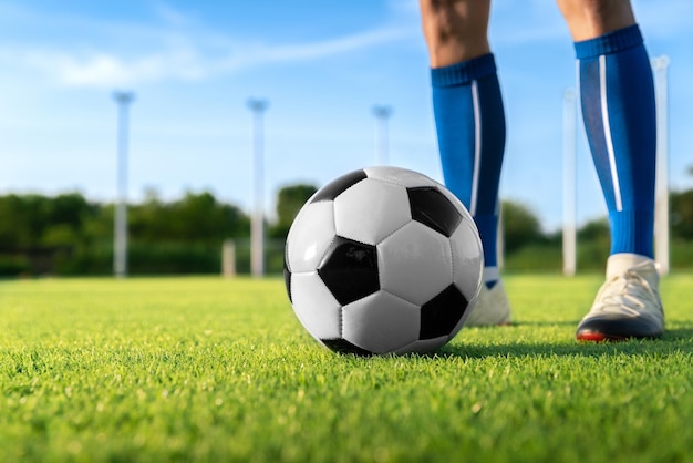 Футболист установил футбольный мяч для удара со штрафного удара или удара, чтобы выиграть счет на травяном стадионе