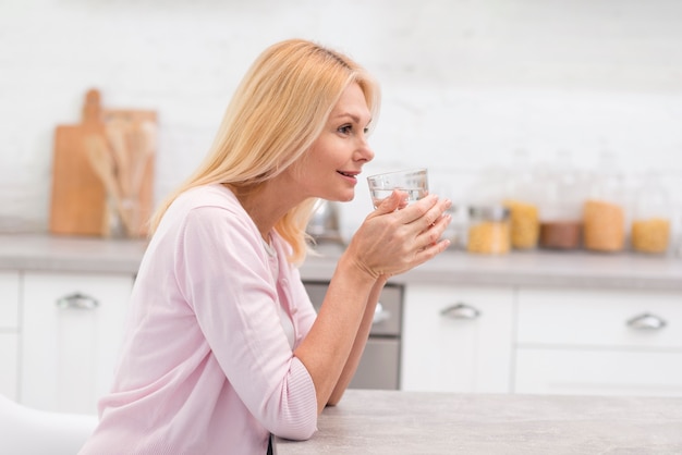Portrait of mature woman drinking a glass of water