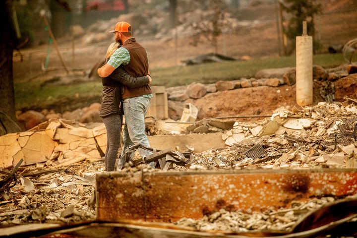 Chris and Nancy Brown embrace while searching through the remains of their home, leveled by the Camp fire, in Paradise, California, on Monday.