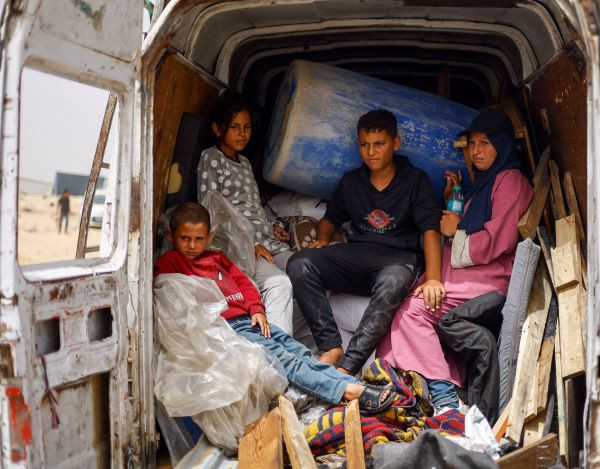 Avenue of escape: Displaced Palestinians of the Salman family ride in a vehicle on May 27, 2024, as they prepare to flee Rafah in the southern Gaza Strip following a nearby Israeli strike. 