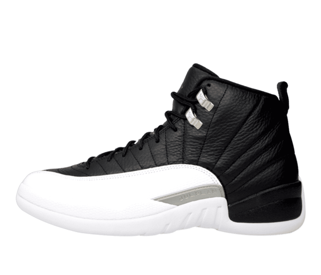 Side view of a black and white Air Jordan 12 shoe. The bottom half is bright white and the top is black corium leather going down the back of the heel to the bottom of the shoe. At the shoelace eyelet are two silver ring-like tags.
