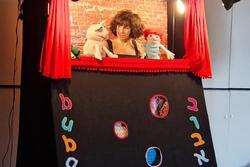 Woman with puppets on each hand staging a puppet show