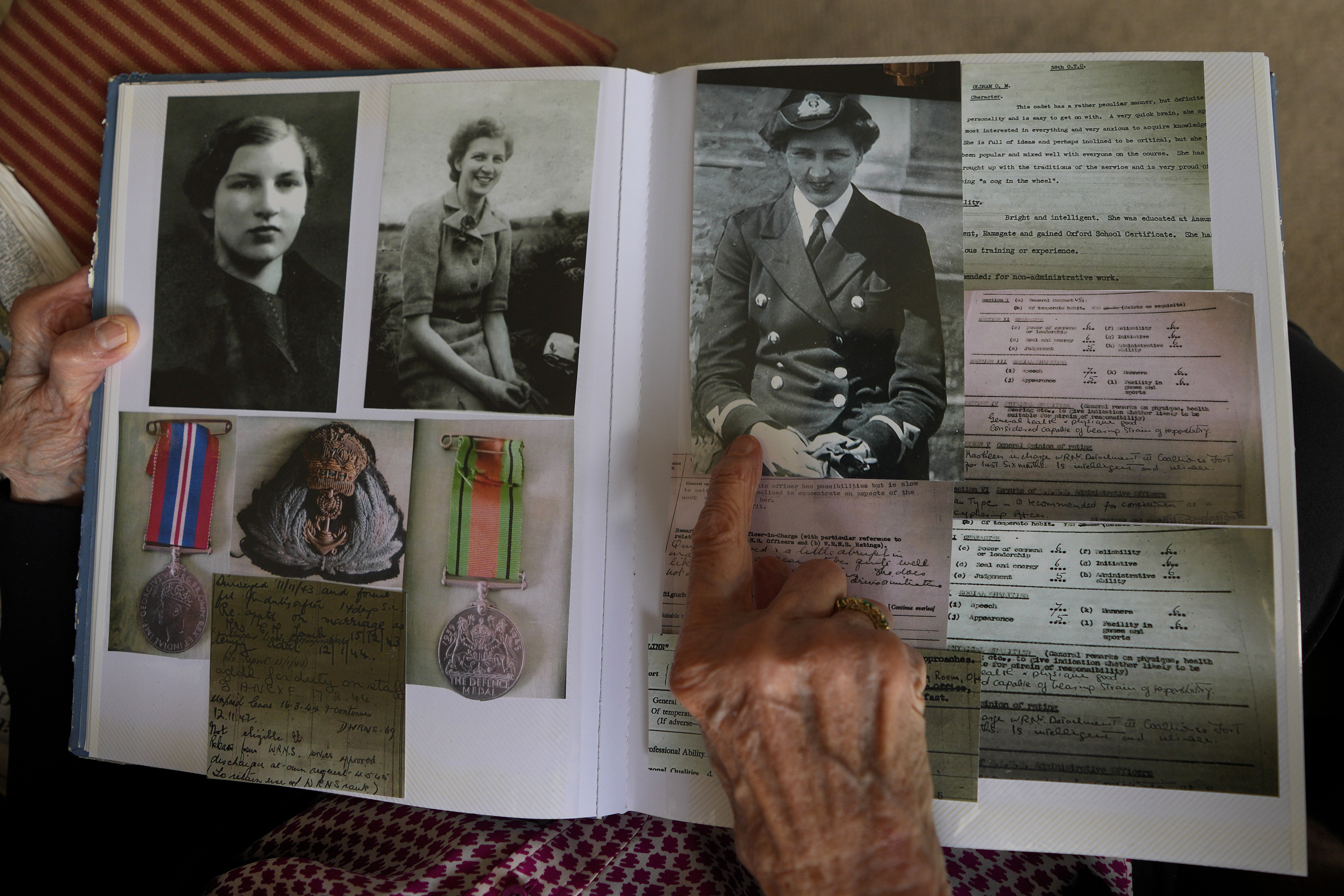 Christian Lamb who was a serving Wren at the time of D-Day, shows pictures of herself in uniform, in a photograph album at her home in London, Thursday, April 11, 2024. D-Day, took place on June 6, 1944, the invasion of the beaches at Normandy in France by Alied forces during World War II.(AP Photo/Kirsty Wigglesworth)