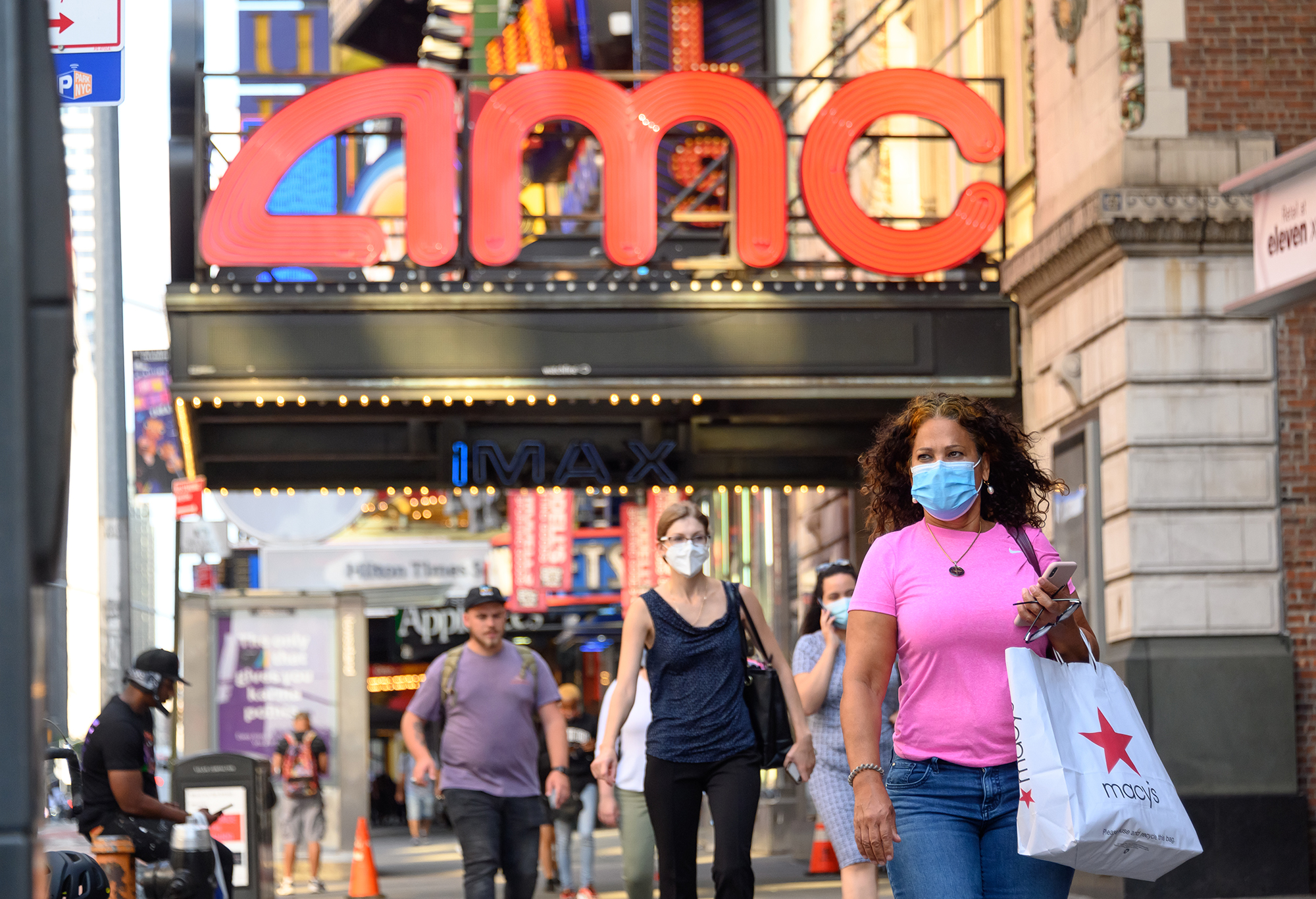People wear protective face masks outside the AMC Empire 25 movie theater in Times Square on Aug. 5, 2020 in New York City. (Noam Galai/Getty Images)
