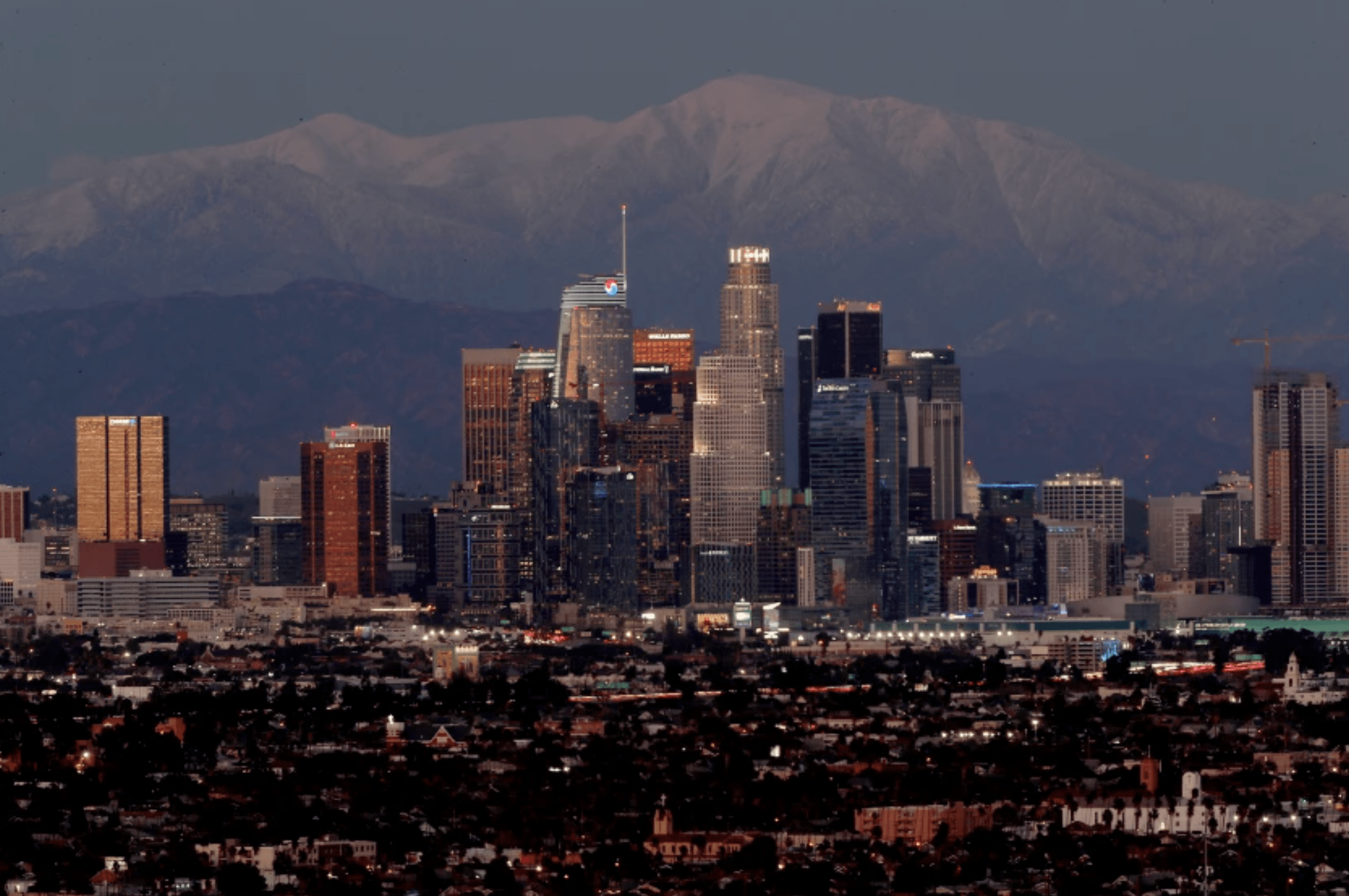 Snow covers Mt. Baldy behind the Los Angeles skyline on Wednesday. The recent cold weather is expected to give way to a warming trend. (Luis Sinco/Los Angeles Times)