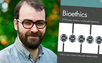 Sean Aas with the cover of his new book Bioethics: 50 Puzzles, Problems, and Thought Experiments