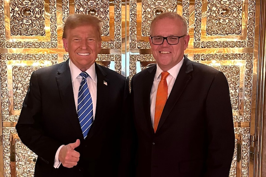 Donald Trump and Scott Morrison stand in front of a gilded door. Mr Trump is doing a thumbs up.