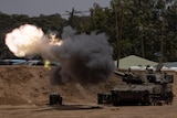 Fire flashes from the canon of a tank