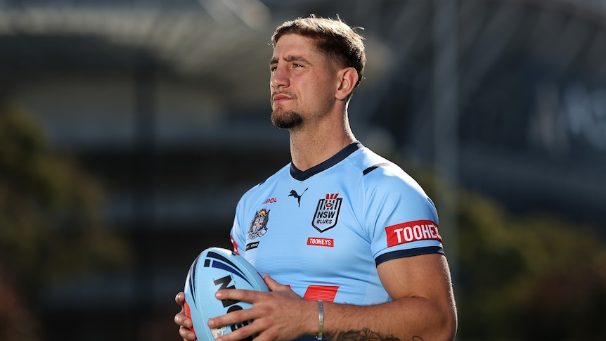 A man poses in a State of Origin jersey before a match
