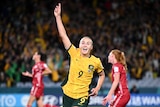 Footballer Caitlin Foord running in celebration, finger in the air, after socring for her country