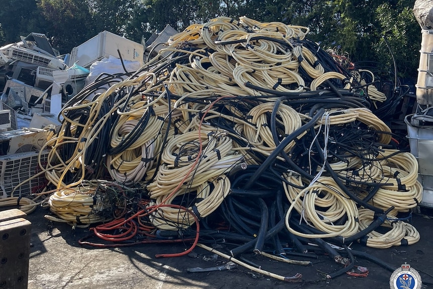 A large pile of cables are piled up next to each other in a car park.