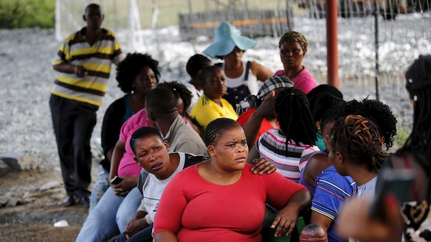 Relatives wait outside the Lily mine site in South Africa after a cave-in trapped 90 workers.