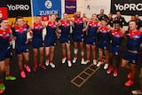 The Melbourne Demons celebrate after a win in 2023.