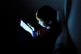 A child scrolls through a tablet.